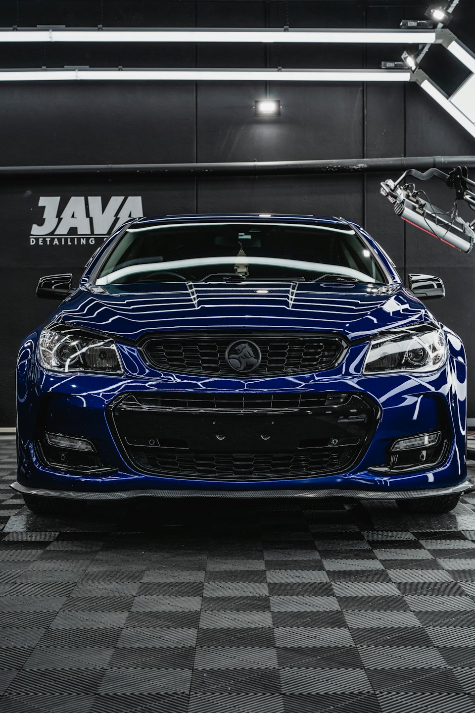 ディテーリング施設内に駐車された、磨き上げられた濃紺の車。